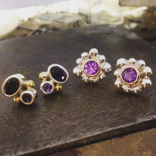 Finished these little studs tonight!! On the left are oval Iolite and Amethyst set in Sterling Silver with 22ct gold granules. Right are amethyst set in 9ct Rose Gold Bezels with bright silver granules in odd sizes. Both will have my favourite wide fleur butterflies backs which keep them sitting perfectly in the ear without drooping forward.