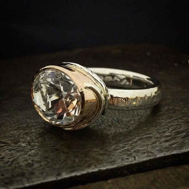 This is a large 15 x 11mm Killiecrankie Diamond. Over 10 carats!! The Rose gold setting is slightly tapered which was a real challenge with this one as I don't use a tapering punch for these, it's hand done! A silver lining on the inside of the rose gold reflects the beautiful sparkle of the topaz. I have wrapped beaten silver wire around the setting which kicks up into a point at the ends. Chunky silver tool marked band.