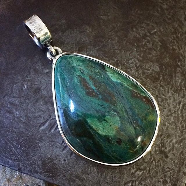 SALE!! Lovely! All set! This stone I cut from rough which came from Arizona. It's called Campitos Sunrise displaying greens & blues with bit of deep red. It's set in Sterling silver with light hammer marks and a little oxidisation for depth and contrast. A lovely chunky piece Measures 56mm long including bail and 29mm wide. I'm selling this piece as a slight 2nd because of a barely visible hairline fracture which annoyed me at first although now I've set it I'm totally happy with it Beautiful stone! $180 AU plus post. I have a black silk rope cord or a black waxed leather double strand necklet with handmade silver clasp as optional extras. Please message me with any questions